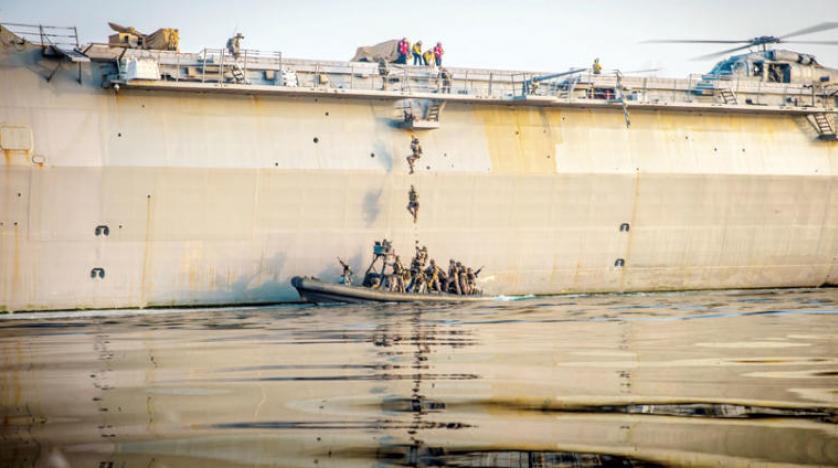 عناصر من المارينز يتسلقون سلمًا على متن سفينة النقل البرمائية «يو اس اس جون ب. مورثا» في الخليج العربي