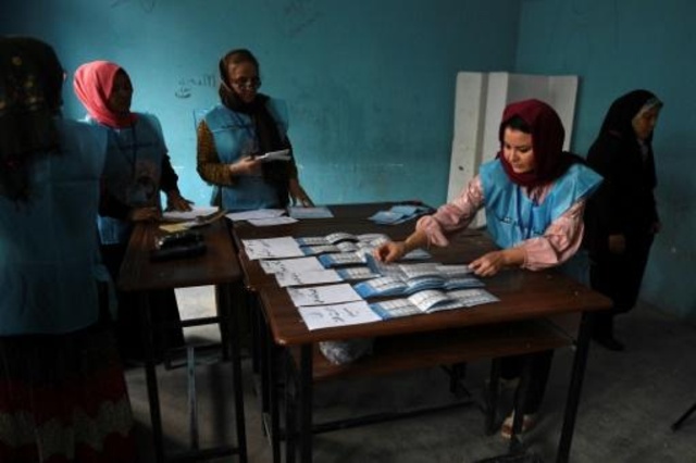 مسؤولو لجنة الانتخابات الأفغانية المستقلة اثناء عملية فرز الأصوات في الانتخابات الرئاسية في مركز اقتراع في مزار شريف