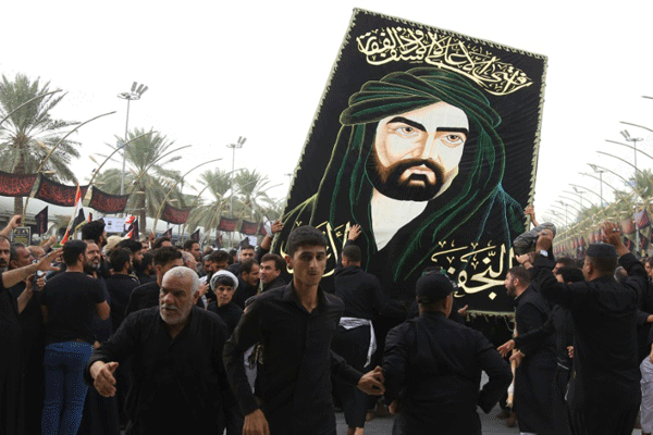  عراقيون يرفعون رسمًا للإمام علي أثناء إحياء ذكرى الأربعين في كربلاء السبت في 19 أكتوبر 2019