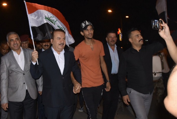 وزير الداخلية العراقي ياسين الياسري يتوسط المتظاهرين رافعا العلم العراقي