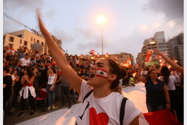 شبان وشابات يحملون الأعلام اللبنانية في وسط بيروت