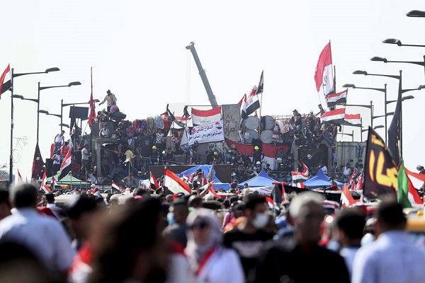 متظاهرون عراقيون خلف متاريس القوات الامنية على جسر الجمهورية المؤدي الى المنطقة الخضراء في بغداد