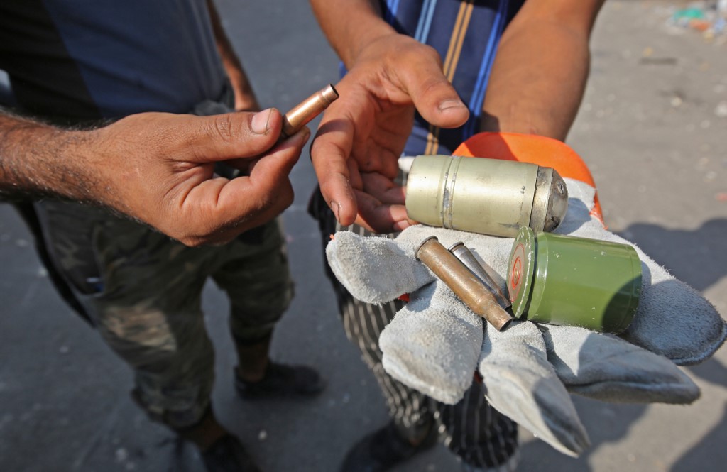 محتجون عراقيون يعرضون بقايا قنابل غاز خانقة استهدفت مسيراتهم