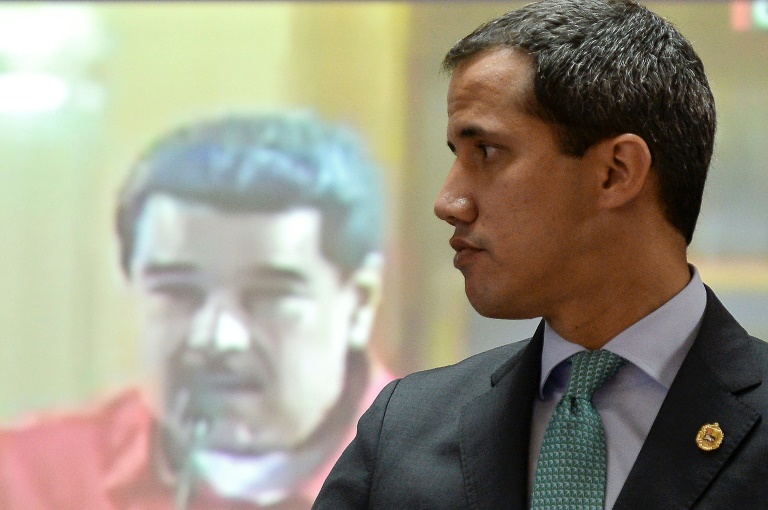 زعيم المعارضة الفنزويلي خوان غوايدو امام صورة للرئيس الفنزويلي نيكولاس مادورو في كراكاس في 3 ايلول/سبتمبر 2019