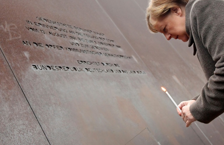 المستشارة الألمانية أنغيلا ميركل تضع شمعة عند النصب التذكاري لجدار برلين خلال إحياء الذكرى الـ30 على سقوطه، 9 نوفمبر 2019