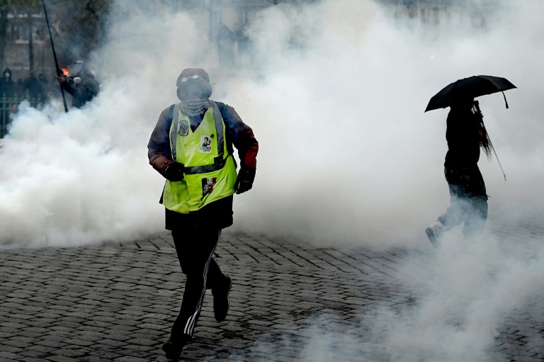 متظاهر في باريس يهرب من الغاز المسيل للدموع في ساحة إيطاليا جنوب العاصمة في 16 نوفمبر 2019