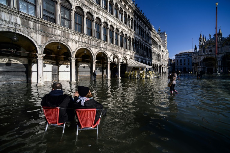 شخصان يجلسان على كراسي مقهى قرب ساحة القديس مرقس في البندقية في 14 نوفمبر 2019