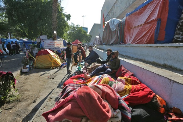 محتجون عراقيون ينامون على جانب طريق في ساحة التحرير في بغداد في 20 نوفمبر 2019
