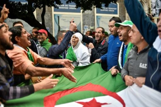 محتجون جزائريون يحملون العلم الوطني ويهتفون شعارات خلال تظاهرة في العاصمة الجزائرية