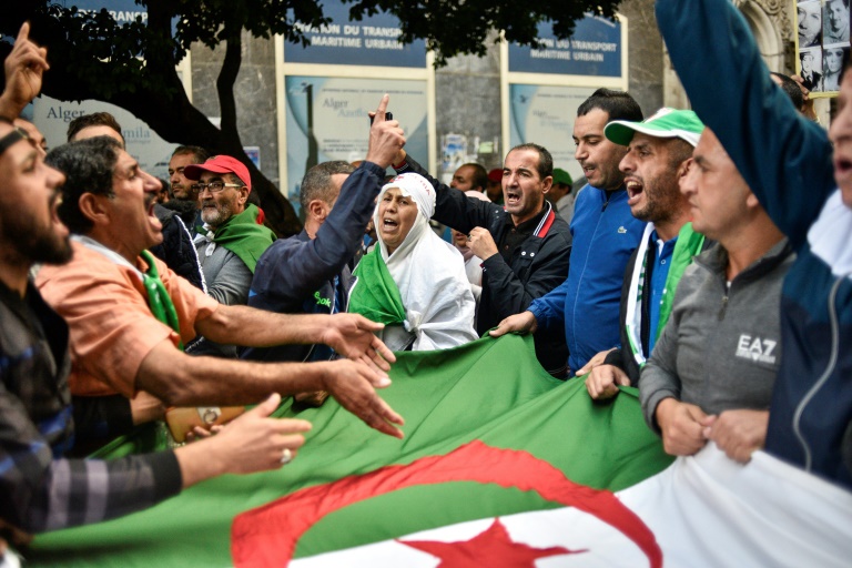 محتجون جزائريون يحملون العلم الوطني ويهتفون شعارات خلال تظاهرة في العاصمة الجزائرية في 25 تشرين الاول/اكتوبر 2019