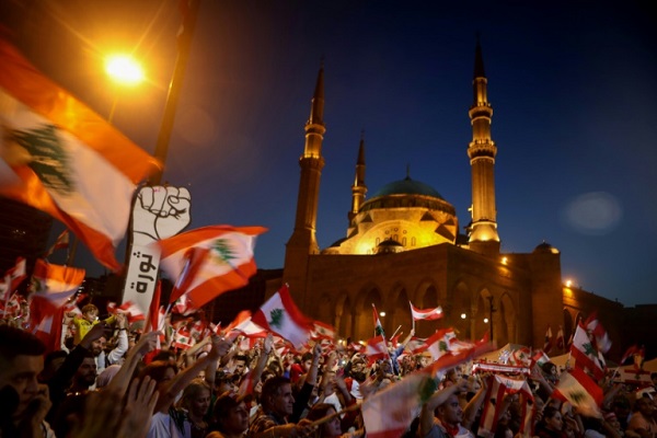 لبنانيون يرفعون الأعلام في وسط بيروت في 17 نوفمبر 2019 مطالبين برحيل الطبقة السياسية مجتمعة بعد دخول حراكهم غير المسبوق شهره الثاني