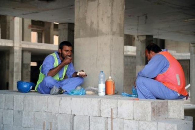 صورة بتاريخ 6 ديسمبر 2016 لعمال اجانب يتناولون الطعام في موقع بناء في العاصمة القطرية الدوحة