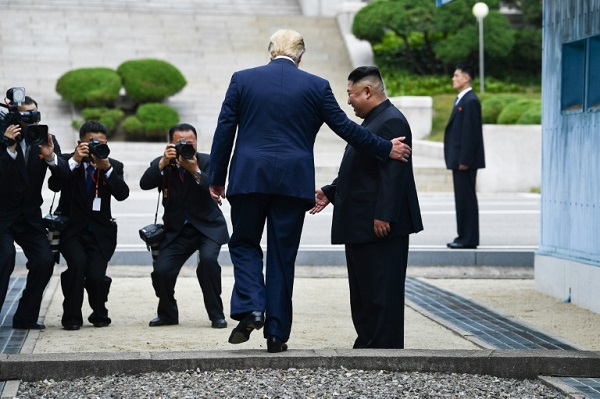 ترمب يعبر خط التماس الذي يفصل بين كوريا الشمالية وكوريا الجنوبية وبجانبه الزعيم الكوري الشمالي كيم جونغ أون في 30 يونيو 2019