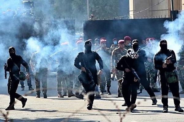 ملثمو البدلات السوداء من عناصر المليشيات العراقية يواجهون المحتجين بالرصاص