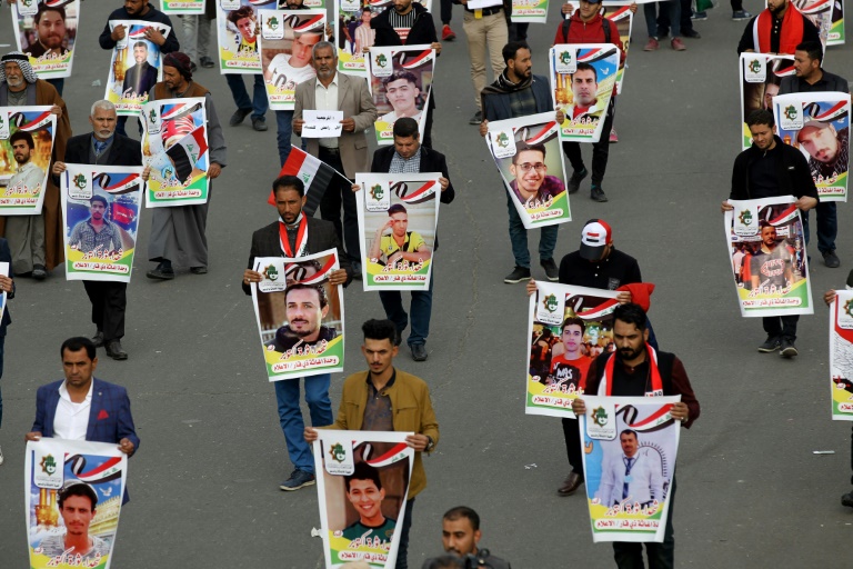 عراقيون يحملون صور متظاهرين قتلوا في ساحة التحرير في بغداد في السادس من ديسمبر 2019