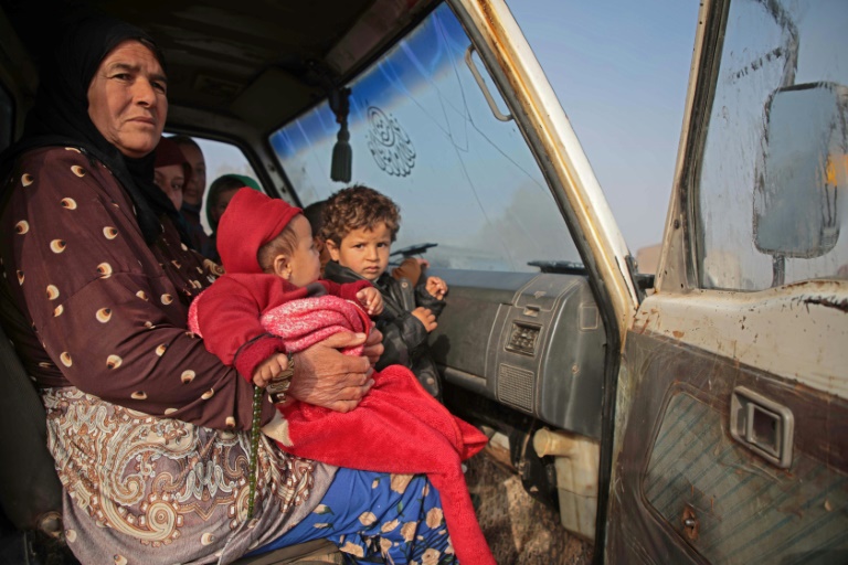سوريون يجلسون في مركبة أثناء توجههم نحو المناطق الشمالية من محافظة إدلب