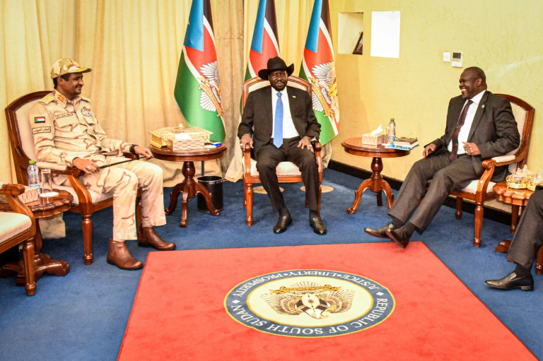 رئيس جنوب السودان سلفا كير (وسط) يجلس وسط زعيم المعارض رياك مشار (يمين) ونائب رئيس المجلس السيادي السوداني محمد حمدان دقلو (يسار) بعد جلسة مباحثات في مجلس الدولة في جوبا في 16 كانون الأول/ديسمبر 2019.