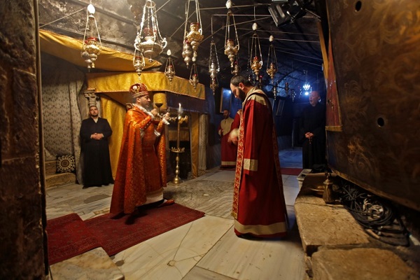 كهنة يؤدون الصلوات داخل مغارة الميلاد في كنيسة المهد في بيت لحم