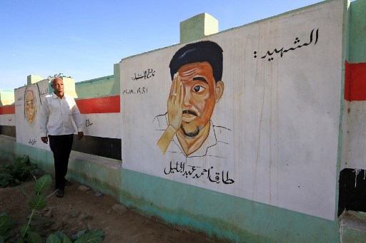 مواطن سوداني يمر أمام رسم لأحد قتلى الاحتجاجات التي أطاحت بالبشير في عطبرة