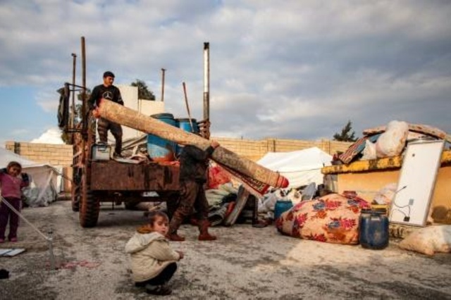 سوريون ينزلون أغراضاً من شاحنة في مخيم للنازحين قرب مدينة دانا في محافظة إدلب في شمال غرب سوريا في 27 كانون الأول/ديسمبر 2019