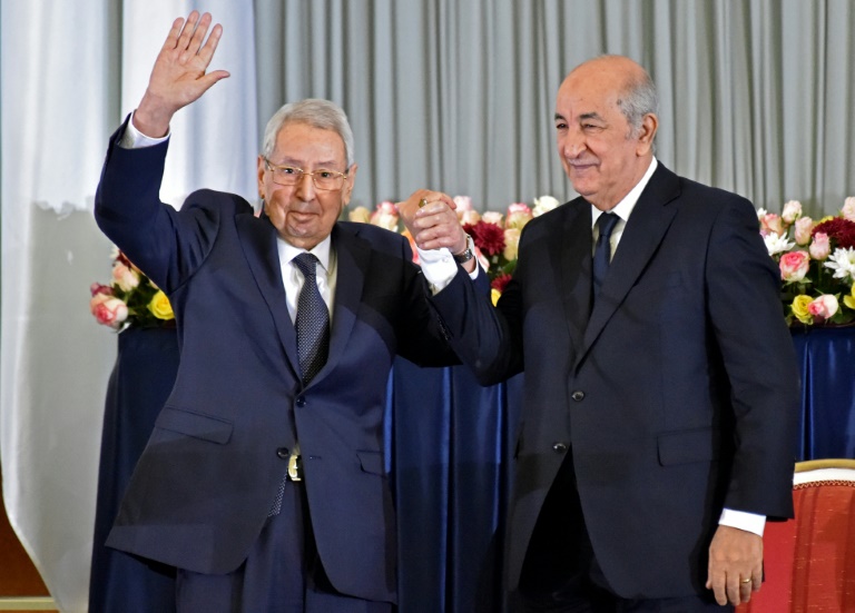 الرئيس الجزائري عبد المجيد تبون(يمين) يودع الرئيس المؤقت عبد القدر بن صالح بعد تسلمه مهامه في 19 كانون الأول/ديسمبر 2019 بالجزائر العاصمة.