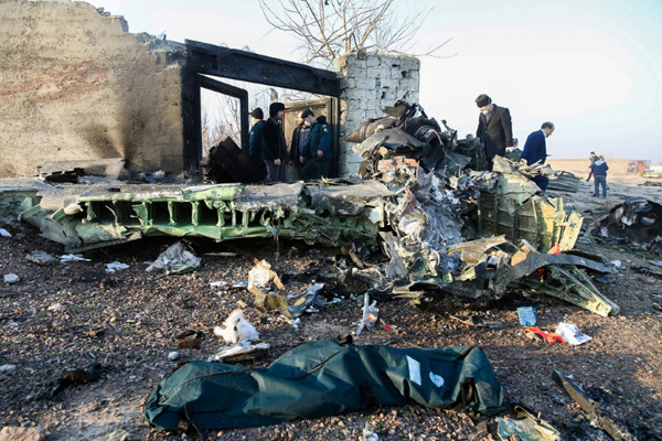 أشخاص بجانب حطام الطائرة الأوكرانية التي تحطمت في طهران بتاريخ 8 يناير 2020