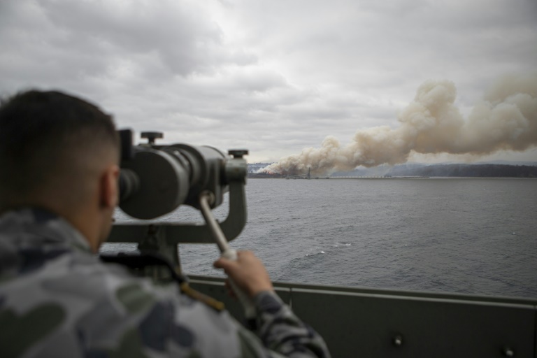 صورة نشرتها وزارة الدفاع الأسترالية في 6 يناير تظهر جنديا في البحرية يراقب بالمنظار دخان حريق في نيو ساوث ويلز