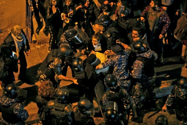 عناصر من مكافحة الشغب أثناء محاولتهم ليل 15 يناير 2020 توقيف متظاهر أمام مقر قيادة شرطة بيروت