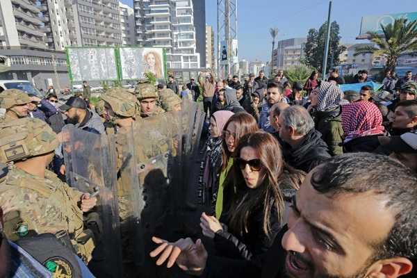 متظاهرون يقفون وجهاً لوجه أمام عناصر من الجيش اللبناني في مدينة طرابلس في شمال لبنان في 14يناير 2020 