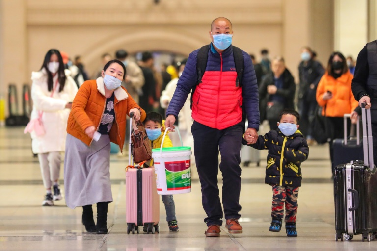 مسافرون يرتدون أقنعة وقائية في محطة هانكو للقطارات في ووهان الصينية في 21 كانون الثاني/يناير 2020