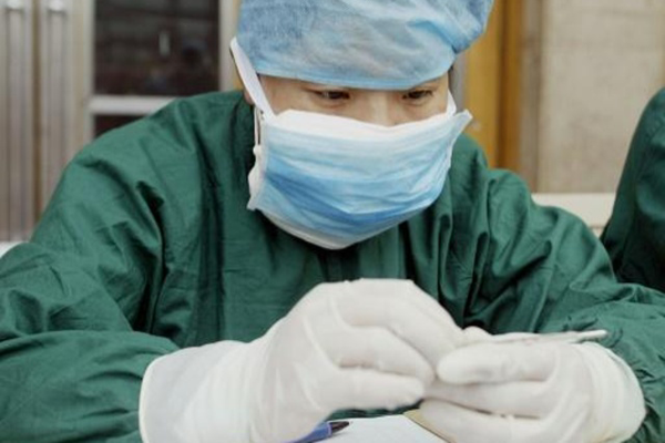 مسؤول في قطاع الصحة يفحص حرارة عامل مهاجر في محطة قطار في بكين في 21 مايو 2003