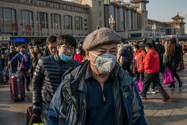 صينيون يرتدون أقنعة مع وصولهم إلى محطة قطارات في بكين في 21 يناير 2020