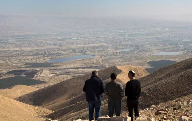 ثلاثة رجال ينظرون لمنطقة غور الأردن