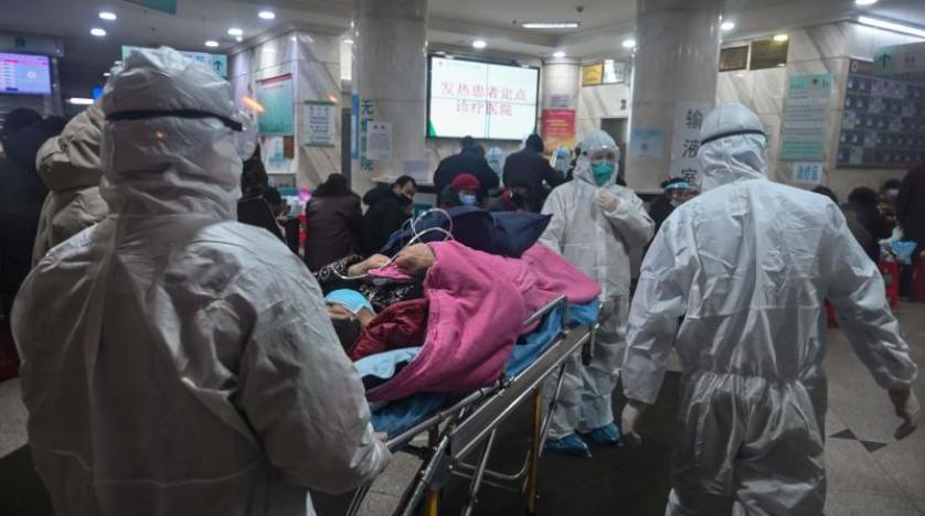 طاقم طبي ينقل مريضاً بمستشفى في ووهان الصينية (أ.ف.ب)