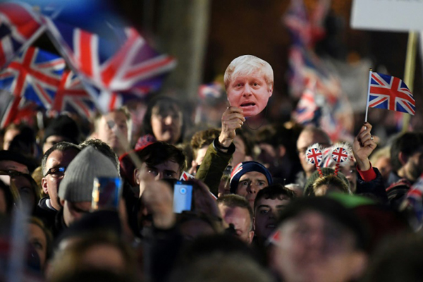 أنصار لبريكست يلوّحون بأعلام بريطانية وصور رئيس الوزراء بوريس جونسون في لندن في 31 يناير 2020