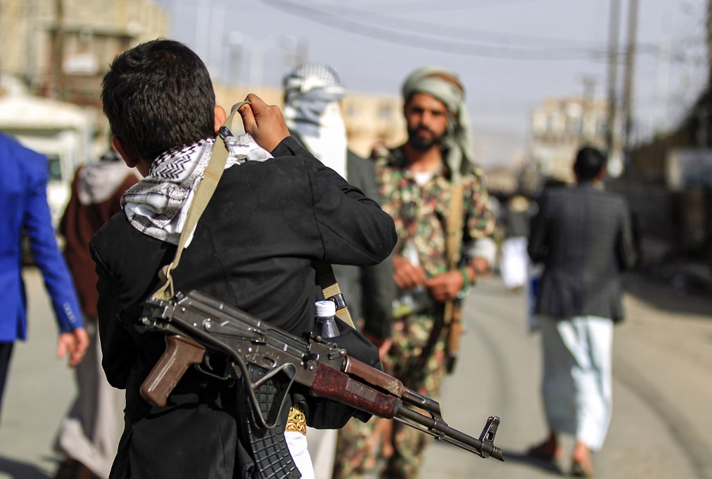 طفل يمني قاصر يحمل سلاحا في صنعاء أمام أنظار مقاتلي الحوثي