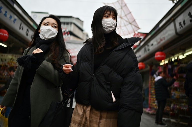 فتاتان في الصين ترتديان قناعا خوفا من فيروس كورونا