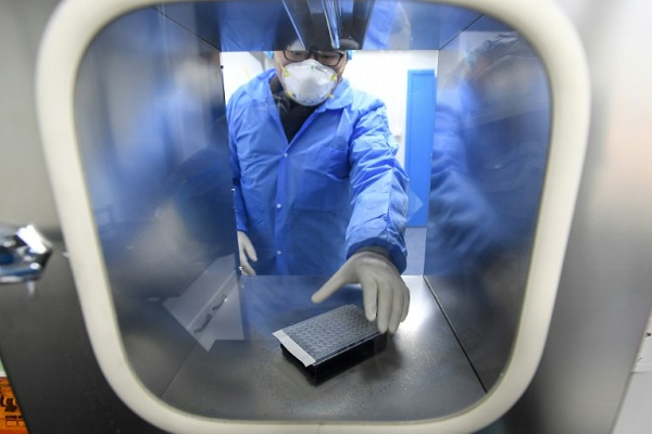 فني في مختبر يتلقى عينات من أشخاص يشتبه بإصابتهم بفيروس كورونا في ووهان في 6 فبراير 2020