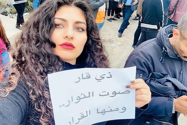 متظاهرة عراقية ترفع شعاراً لنصرة محتجي محافظة ذي قار