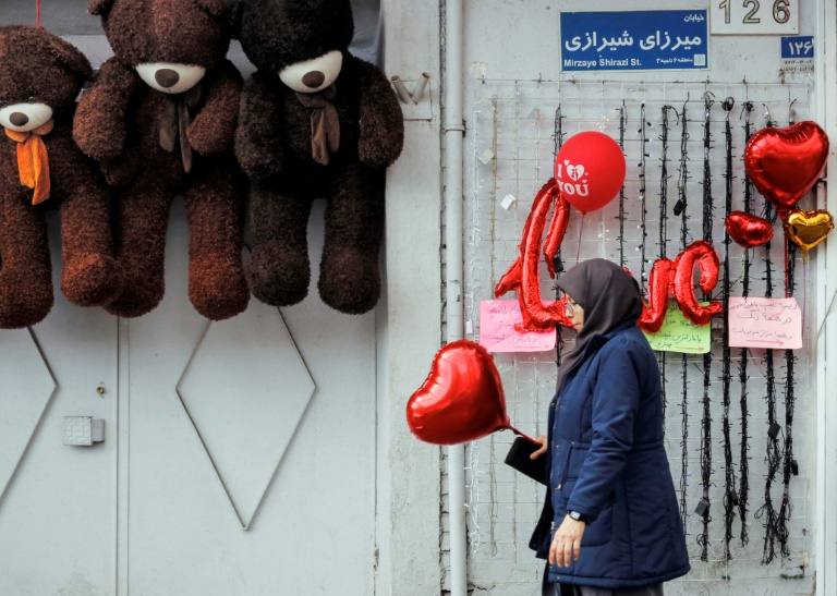 امرأة تحمل بالونا على شكل قلب في أحد شوارع العاصمة الإيرانية طهران في يوم عيد الحب في 14 شباط/فبراير 2020