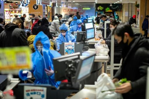 متسوقون في سوق في شنيانغ في شمال شرق الصين يضعون أقنعة وقاية طبية في 10 فبراير 2020