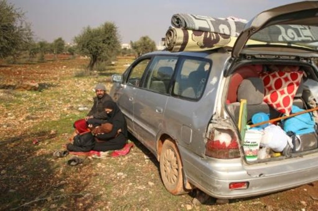 غصن وزوجها أمام سيارتهما قرب بلدة معرة مصرين في محافظة ادلب بشمال غرب سوريا في 06 فبراير 2020