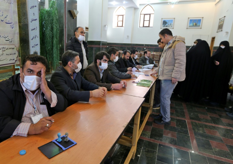 مسؤولون عن الانتخابات الإيرانية يرتدون أقنعة واقية خلال الانتخابات التشريعية على أطراف طهران الجنوبية بتاريخ 21 شباط/فبراير 2020