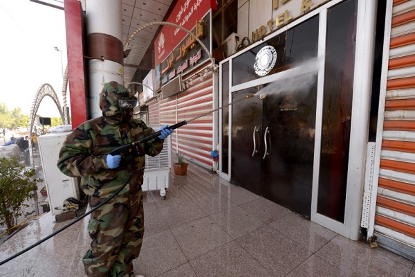 احد عناصر الدفاع المدني يعقم مدخل وجدران موقع الحجر الصحي لطلاب احدى الحوزات الدينية في النجف العراقية الاربعاء في 26 فبراير 2020
