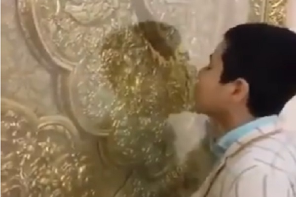 صورة من مقطع فيديو يظهر تقبيل أحد الأضرحة في إيران