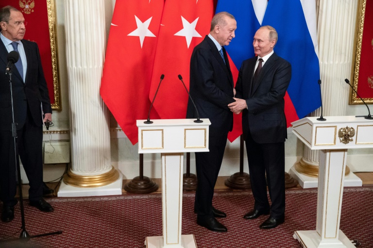 مصافحة بين الرئيس الروسي فلاديمير بوتين ونظيره التركي رجب طيب اردوغان في ختام مؤتمر صحافي مشترك في موسكو في الخامس من اذار/مارس 2020