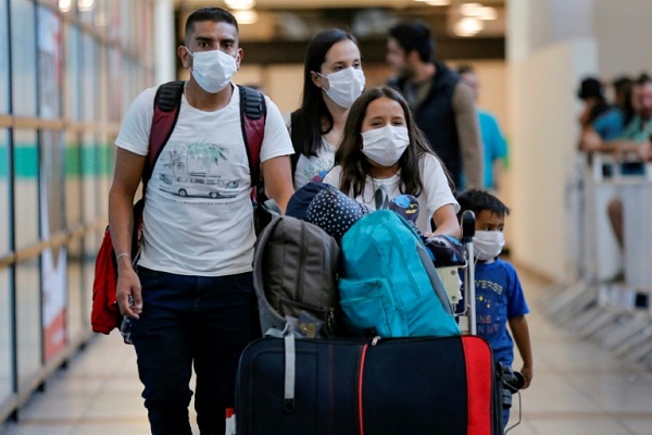 مسافرون يضعون كمامات طبية في مطار سانتياغو في تشيلي في 3 مارس 2020