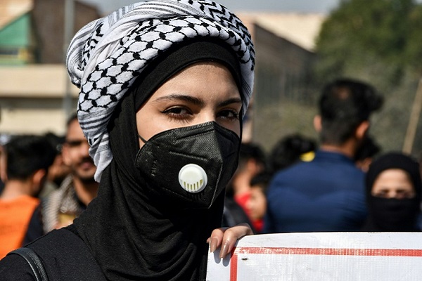 طالبة عراقية تضع قناعا للوقاية من فيروس كورونا المستجد في الناصرية في جنوب العراق في الأول من مارس 2020