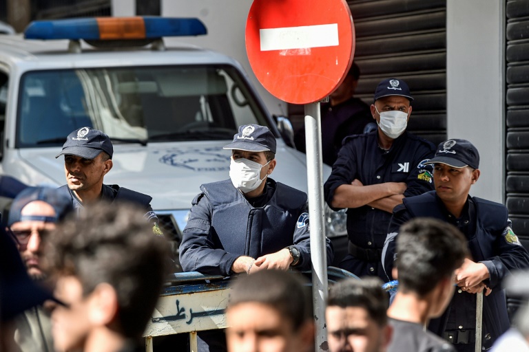 عناصر في شرطة مكافحة الشغب الجزائرية يضعون اقنعة واقية خلال تظاهرة مناهضة للحكومة في العاصمة في السادس من اذار/مارس 2020