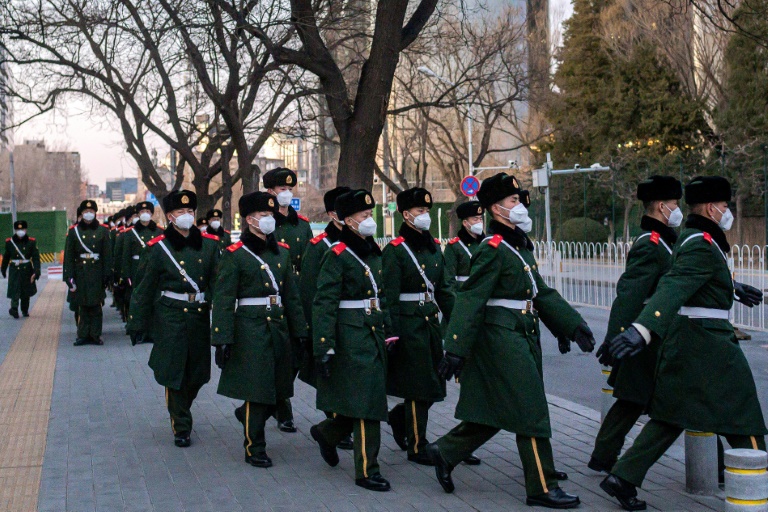 صورة لعناصر من قوات الأمن الصينية يرتدون أقنعة في أحد شوارع بكين في 1 مارس 2020